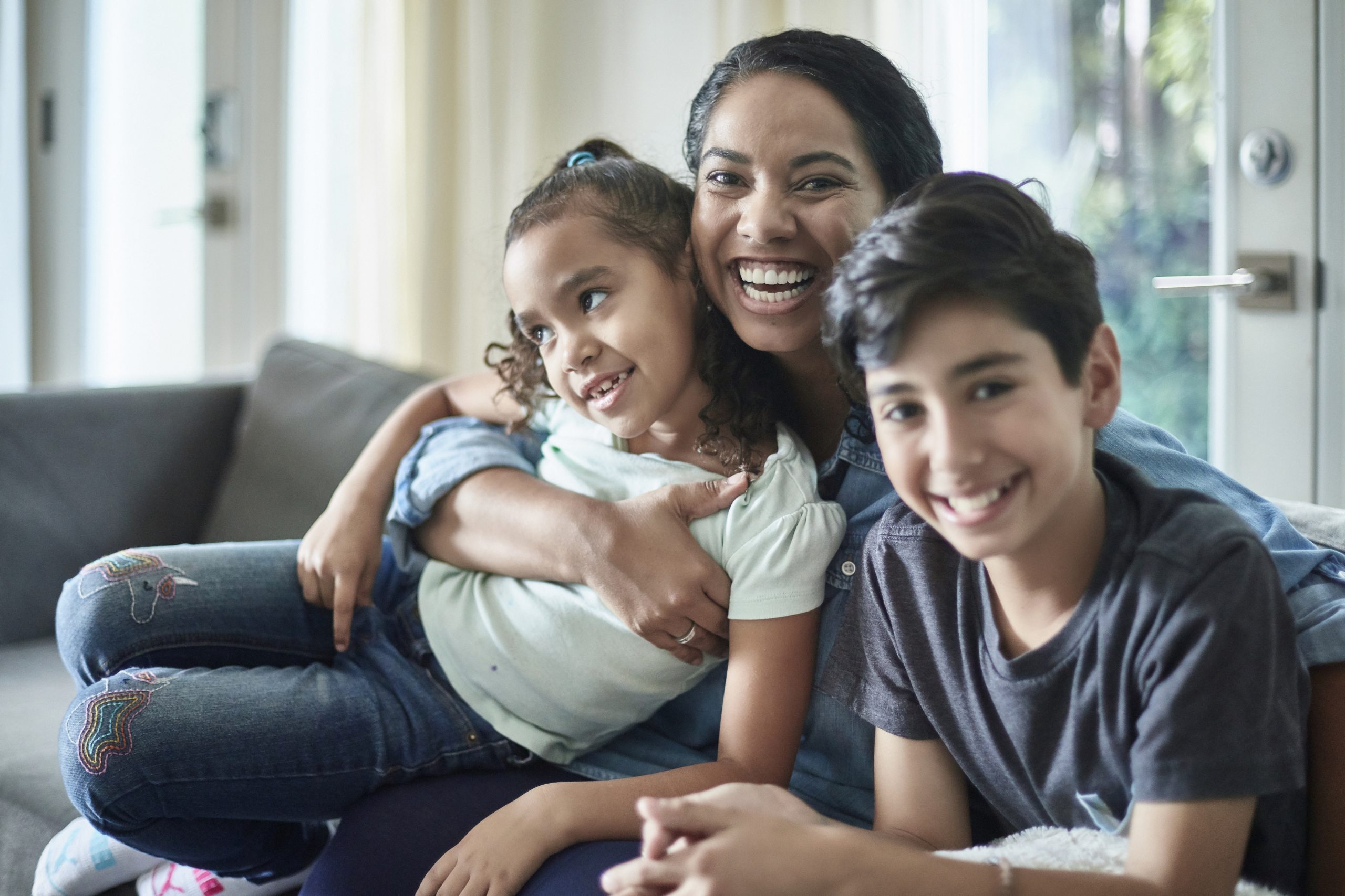 Smiling Mixed Race Mother with Young Children on Sofa
