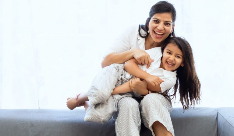 Mother and daughter smiling and hugging