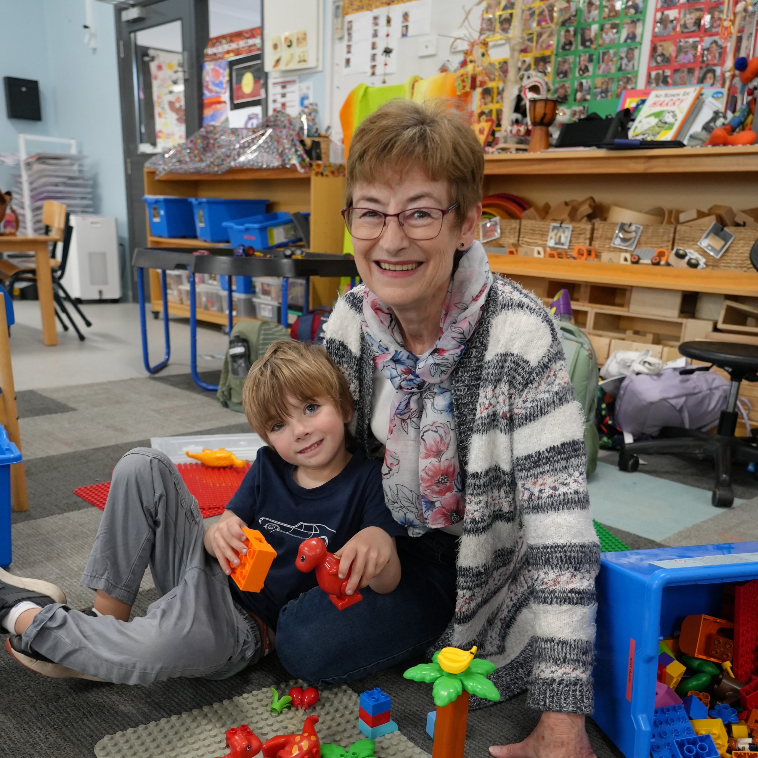 This is a photo of Belinda, she is sitting with a kindergarten child, he is playing with blocks